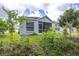Backyard featuring trees, plants and a screened patio at 26343 Whirlaway Ter, Wesley Chapel, FL 33544