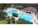 Aerial view of the community pool area featuring multiple pools, a splash pad, and a playground at 26343 Whirlaway Ter, Wesley Chapel, FL 33544