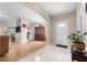 Open concept foyer with tile flooring, hardwood flooring, a pendant light, and a front door at 26343 Whirlaway Ter, Wesley Chapel, FL 33544