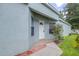 Exterior view of front entrance featuring a white door, brick walkway, and a small garden at 26343 Whirlaway Ter, Wesley Chapel, FL 33544