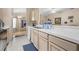A bright kitchen with white countertops, stainless steel sink, and wood cabinets offers ample space at 26343 Whirlaway Ter, Wesley Chapel, FL 33544