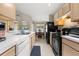 Open kitchen with black appliances, white counters, and a view into the dining room at 26343 Whirlaway Ter, Wesley Chapel, FL 33544
