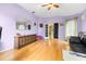 Living room with hardwood floors, black leather sofa and doorway to adjacent room at 26343 Whirlaway Ter, Wesley Chapel, FL 33544