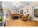 Open floor plan with hardwood floors, ceiling fan, large leather sofa and access to other rooms at 26343 Whirlaway Ter, Wesley Chapel, FL 33544