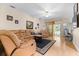 Comfortable living room features hardwood flooring, neutral paint, fan, and a sliding glass door to the yard at 26343 Whirlaway Ter, Wesley Chapel, FL 33544