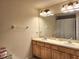 Bathroom featuring double sinks with wood cabinets, a large mirror, and neutral decor at 26541 Chimney Spire Ln, Wesley Chapel, FL 33544