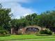 Community entrance sign 'The Bay at Cypress Creek' amidst lush landscaping under a blue sky at 26541 Chimney Spire Ln, Wesley Chapel, FL 33544
