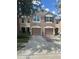 Townhome exterior with two-car garages, brick accents, and neat landscaping at 26541 Chimney Spire Ln, Wesley Chapel, FL 33544