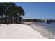 White sandy beach overlooking the water with a park bench and lush green trees at 2700 Bayshore Blvd # 5307, Dunedin, FL 34698