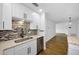 Updated kitchen features stainless appliances, white cabinets, tile backsplash, and wood flooring at 2700 Bayshore Blvd # 5307, Dunedin, FL 34698