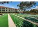 Exterior view of a community shuffleboard court, with a mature tree and the condos in the background at 2700 Bayshore Blvd # 5307, Dunedin, FL 34698