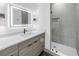 Elegant bathroom featuring wood cabinets, stone countertop, a lit mirror, and walk-in shower at 2812 N Massachusetts Ave, Tampa, FL 33602