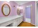 Retro-styled bathroom with lavender walls, decorative mirrors, and a long vanity with a white sink at 321 Belle View Ave, Temple Terrace, FL 33617