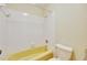 Bathroom featuring a tub and shower combination with white tiles, toilet, and wallpapered walls at 321 Belle View Ave, Temple Terrace, FL 33617