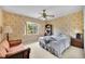 Bedroom with leafy wallpaper, a window view, and a sitting area with a sofa at 321 Belle View Ave, Temple Terrace, FL 33617