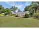 Home's front view featuring a well-kept lawn, classic brickwork, and large windows at 321 Belle View Ave, Temple Terrace, FL 33617