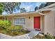 Close-up of the home's entrance with red door, neat landscaping, and house number at 321 Belle View Ave, Temple Terrace, FL 33617