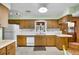 Traditional kitchen with wooden cabinets, white appliances, and a window over the sink at 321 Belle View Ave, Temple Terrace, FL 33617