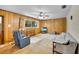 Inviting living room with wood-paneled walls, comfortable seating, and bright natural light from the window at 321 Belle View Ave, Temple Terrace, FL 33617