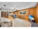 Large living room features wood paneling, built-in bookshelves, and a ceiling fan at 321 Belle View Ave, Temple Terrace, FL 33617