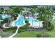 An aerial view shows a pool complex with palm trees surrounded by homes and landscaped areas at 32451 Limitless Pl, Wesley Chapel, FL 33545