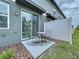 Cozy patio with a table and chairs, set in a private backyard with a white fence at 32451 Limitless Pl, Wesley Chapel, FL 33545