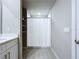 Neutral bathroom featuring tiled floors, a shower with a white curtain, and shelving for storage at 32451 Limitless Pl, Wesley Chapel, FL 33545