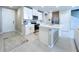 A modern kitchen with white cabinetry, stainless steel appliances, and an island with a sink at 32451 Limitless Pl, Wesley Chapel, FL 33545