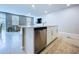 Kitchen island with sink, stainless steel dishwasher and open floor plan to living room with TV and couch at 32451 Limitless Pl, Wesley Chapel, FL 33545