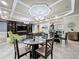 The open living room boasts elegant coffered ceilings, recessed lighting, and a seamless flow to the adjacent dining area at 32451 Limitless Pl, Wesley Chapel, FL 33545