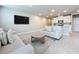 Open-concept living room featuring a large flat screen TV, tile floors, and comfortable seating area at 32451 Limitless Pl, Wesley Chapel, FL 33545