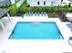 Aerial view of a refreshing pool featuring lounge chairs and well-manicured landscaping at 32451 Limitless Pl, Wesley Chapel, FL 33545
