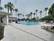 A luxurious pool area is surrounded by palm trees and comfortable lounge chairs, creating a resort-like experience at 32451 Limitless Pl, Wesley Chapel, FL 33545