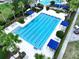 Aerial view of a beautiful pool with lane markers and blue canopies in a landscaped community at 32451 Limitless Pl, Wesley Chapel, FL 33545