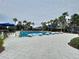 A long, inviting swimming pool is surrounded by lush palm trees, umbrellas and lounge chairs, for relaxation and recreation at 32451 Limitless Pl, Wesley Chapel, FL 33545