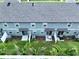 Aerial view of townhouse exteriors featuring patios, lawns, and consistent architectural design at 32451 Limitless Pl, Wesley Chapel, FL 33545