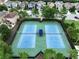 Aerial view of community tennis courts surrounded by lush landscaping and residential homes at 32451 Limitless Pl, Wesley Chapel, FL 33545