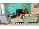 Comfortable living room with a teal accent wall, large TV, plush seating, and lots of natural light at 3313 San Moise Pl, Plant City, FL 33567