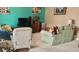Comfortable living room with a teal accent wall, large TV, plush seating, and lots of natural light at 3313 San Moise Pl, Plant City, FL 33567