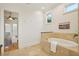 Bright bathroom featuring a soaking tub with tiled surround and view to an adjacent room at 333 30Th N Ave, St Petersburg, FL 33704