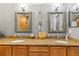 Bathroom featuring dual sinks with granite countertops and decorative framed mirrors at 3402 Melissa Country Way, Lutz, FL 33559