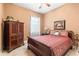 Comfortable bedroom featuring an armoire, side table, and a decorative bed with an ornate headboard at 3402 Melissa Country Way, Lutz, FL 33559