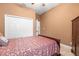 Cozy bedroom featuring a plush bed, neutral walls, and a closet for ample storage space at 3402 Melissa Country Way, Lutz, FL 33559