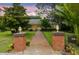 Inviting home entrance with brick pillars and a well-manicured lawn at 3402 Melissa Country Way, Lutz, FL 33559