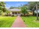 Charming yellow home with a brick walkway and inviting front porch at 3402 Melissa Country Way, Lutz, FL 33559