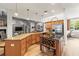 Open kitchen with a large granite island, wine rack, wood cabinets, and a view into the living area at 3402 Melissa Country Way, Lutz, FL 33559