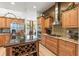 Well-equipped kitchen featuring wood cabinets, granite countertops, stainless steel appliances, and a wine rack island at 3402 Melissa Country Way, Lutz, FL 33559
