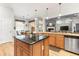 Kitchen island with granite countertops, wooden cabinets and a view to the breakfast nook and living room at 3402 Melissa Country Way, Lutz, FL 33559