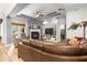 Comfortable living room with a fireplace, ceiling fan, leather furniture, and an open layout at 3402 Melissa Country Way, Lutz, FL 33559