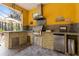 Outdoor kitchen with stainless steel appliances and stone accents under a covered patio at 3402 Melissa Country Way, Lutz, FL 33559